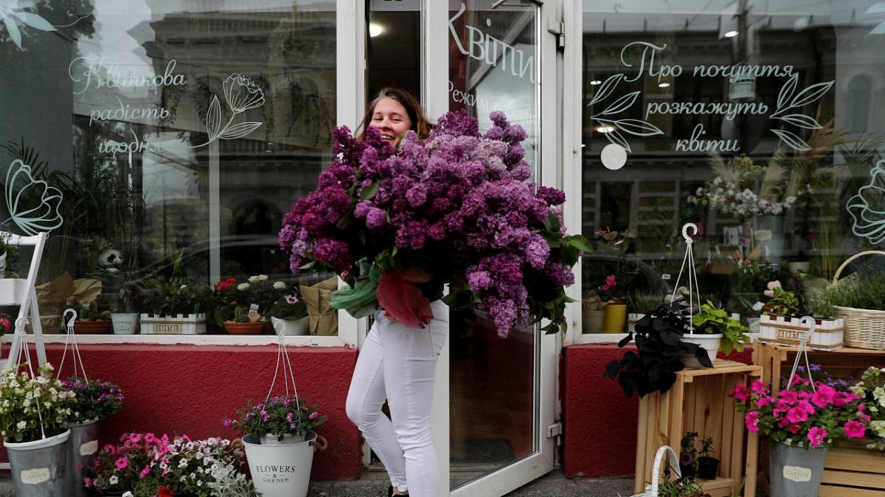 A woman holds a bouquet of flowers outside a flower shop, as Russia's attack on Ukraine continues, in Kyiv. Credit: Reuters file photo