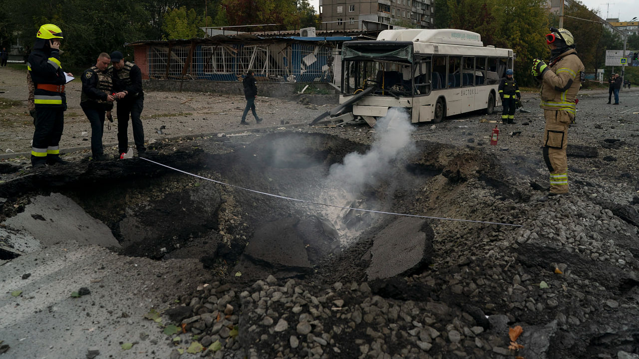 Firefighters and police officers work on a site where an explosion created a crater on the street after a Russian attack in Dnipro, Ukraine, Monday, Oct. 10, 2022. Credit: AP/PTI Photo