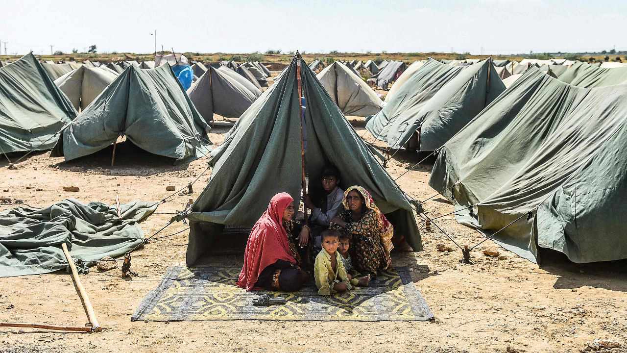 An internally displaced flood-affected family sits outside their tent at a makeshift tent camp in Jamshoro district of Sindh province, September 28, 2022. Credit: AFP File Photo
