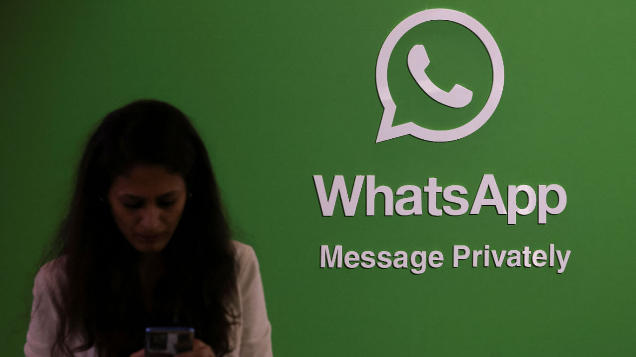 A woman uses her phone next to a logo of the WhatsApp application during Global Fintech Fest in Mumbai, India September 20, 2022. Credit: Reuters File Photo