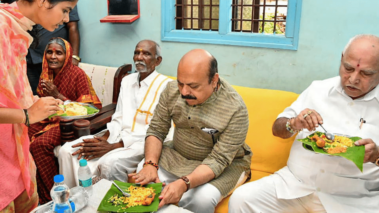 CM Basavaraj Bommai has breakfast with Hirala Kollarappa, a Dalit community member, and his family members. Credit: PTI Photo