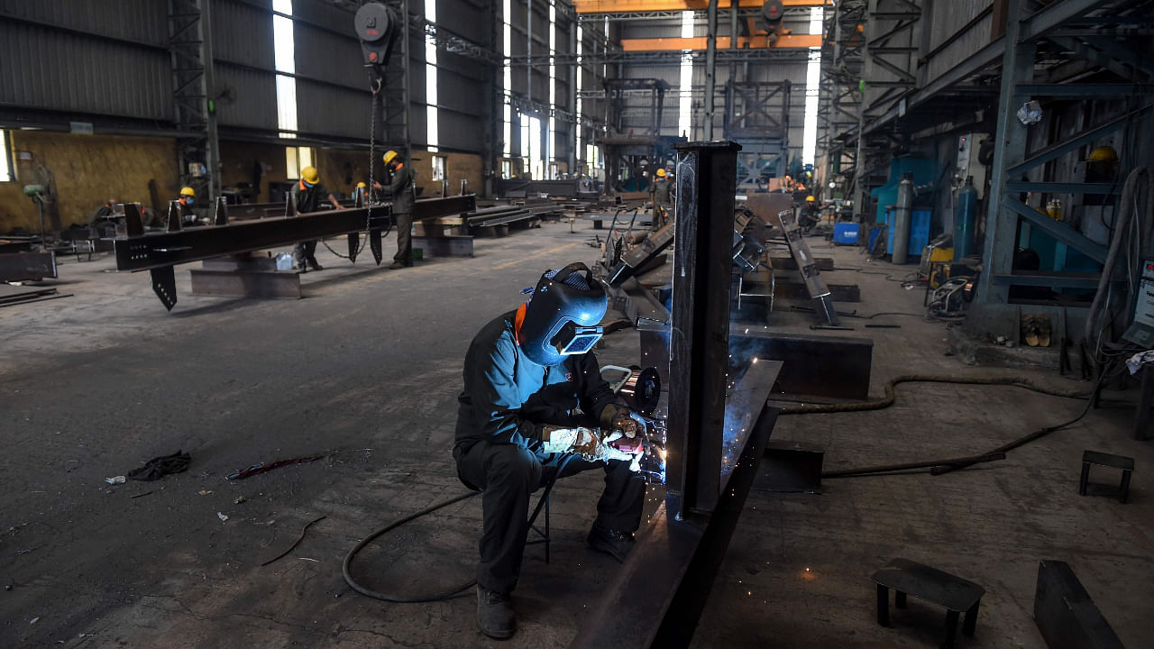 A labourer works at DH Cube Industries, a heavy manufacturing factory, at Vasna Buzarg village, some 40 kms from Ahmedabad on May 14, 2020. Credit: AFP File Photo