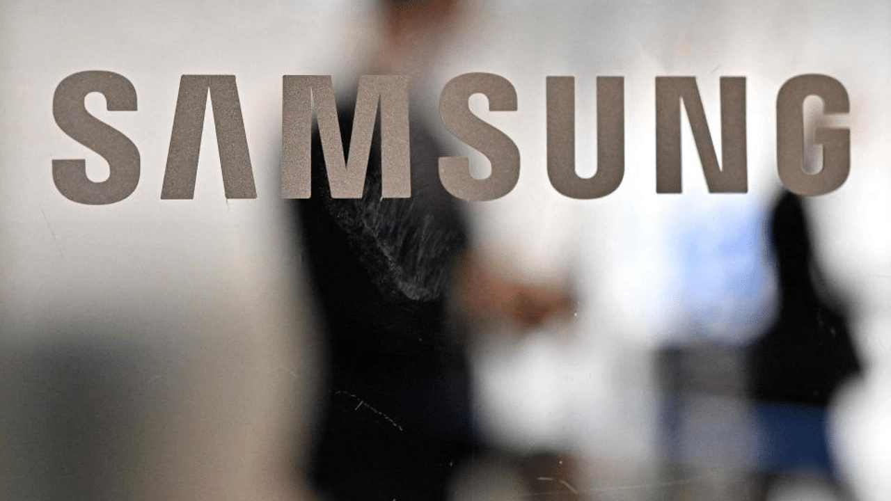 People walk past the Samsung logo displayed on a glass door at the company's building, Credit: AFP Photo