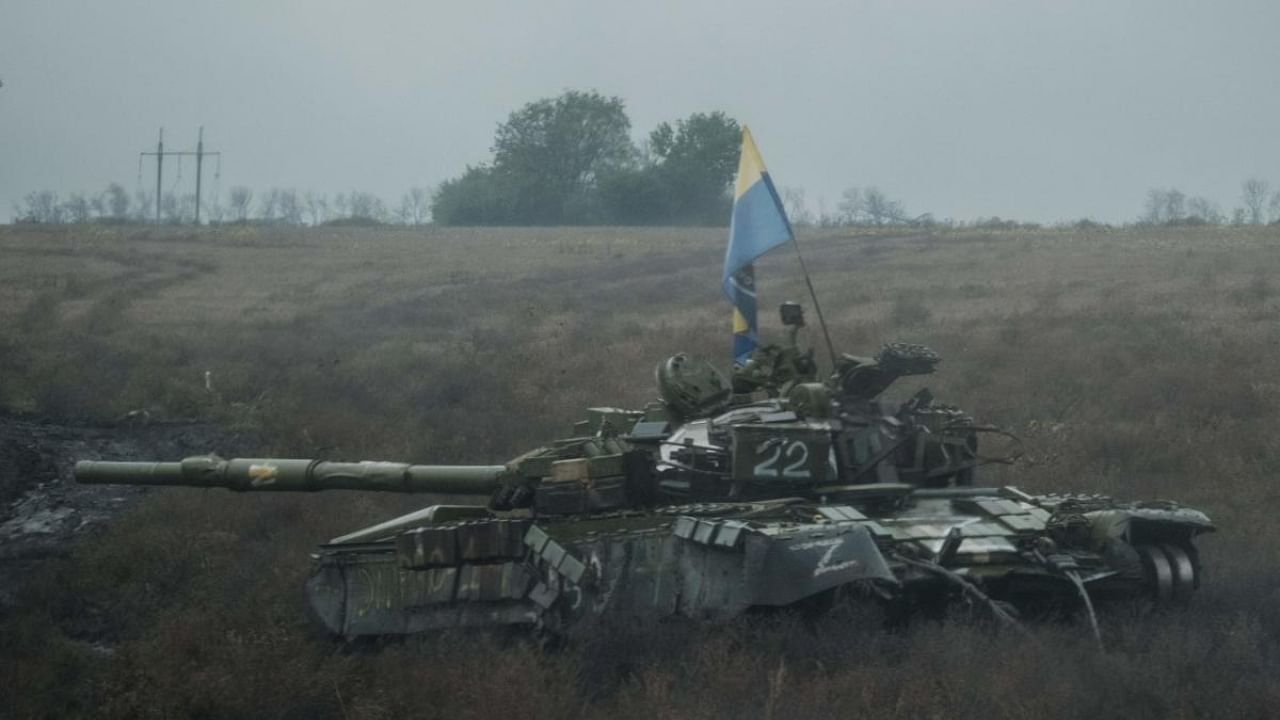 A Ukrainian flag is put on an abandoned Russian tank near Dolina in the Donetsk region, on October 10, 2022, amid the Russian invasion of Ukraine. Credit: AFP Photo