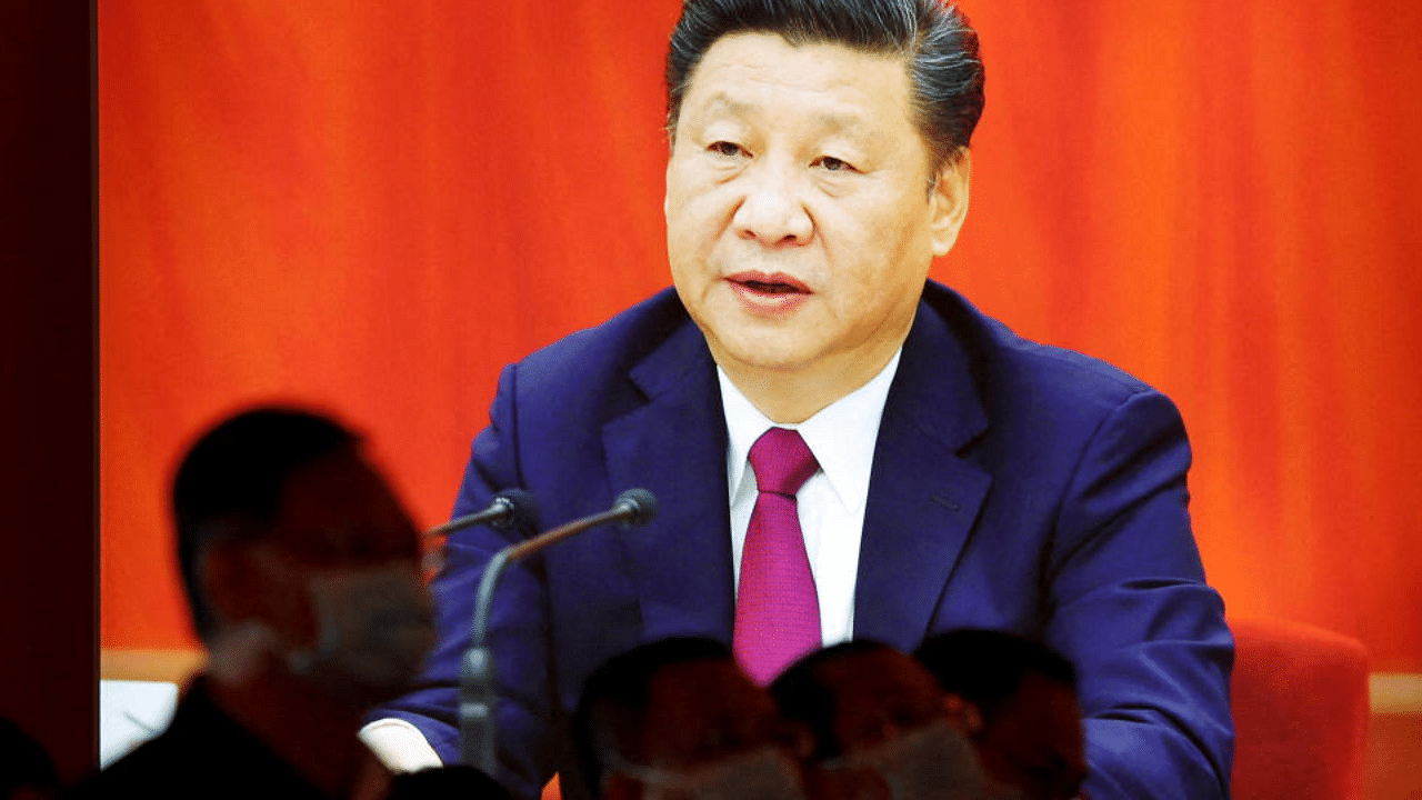 Visitors stand in front of an image of Chinese President Xi Jinping. Credit: Reuters Photo