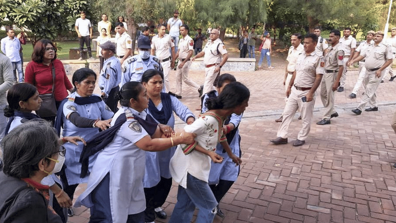 Security personnel remove AISA acivists who had gathered at the Arts Faculty campus of the Delhi University for a public meeting to welcome GN Saibaba. Credit: PTI Photo
