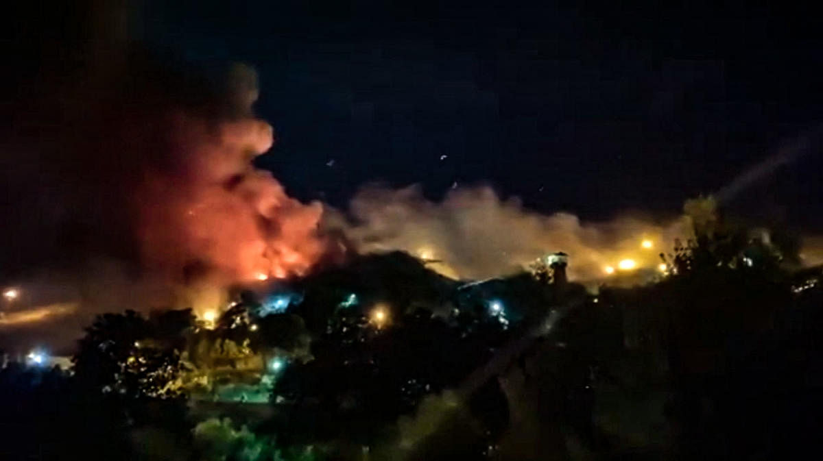 This image grab from a UGC video made available on October 15, 2022, reportedly shows flames and thick smoke rising from the Evin prison, in the northwest of the Iranian capital Tehran. Credit: AFP Photo