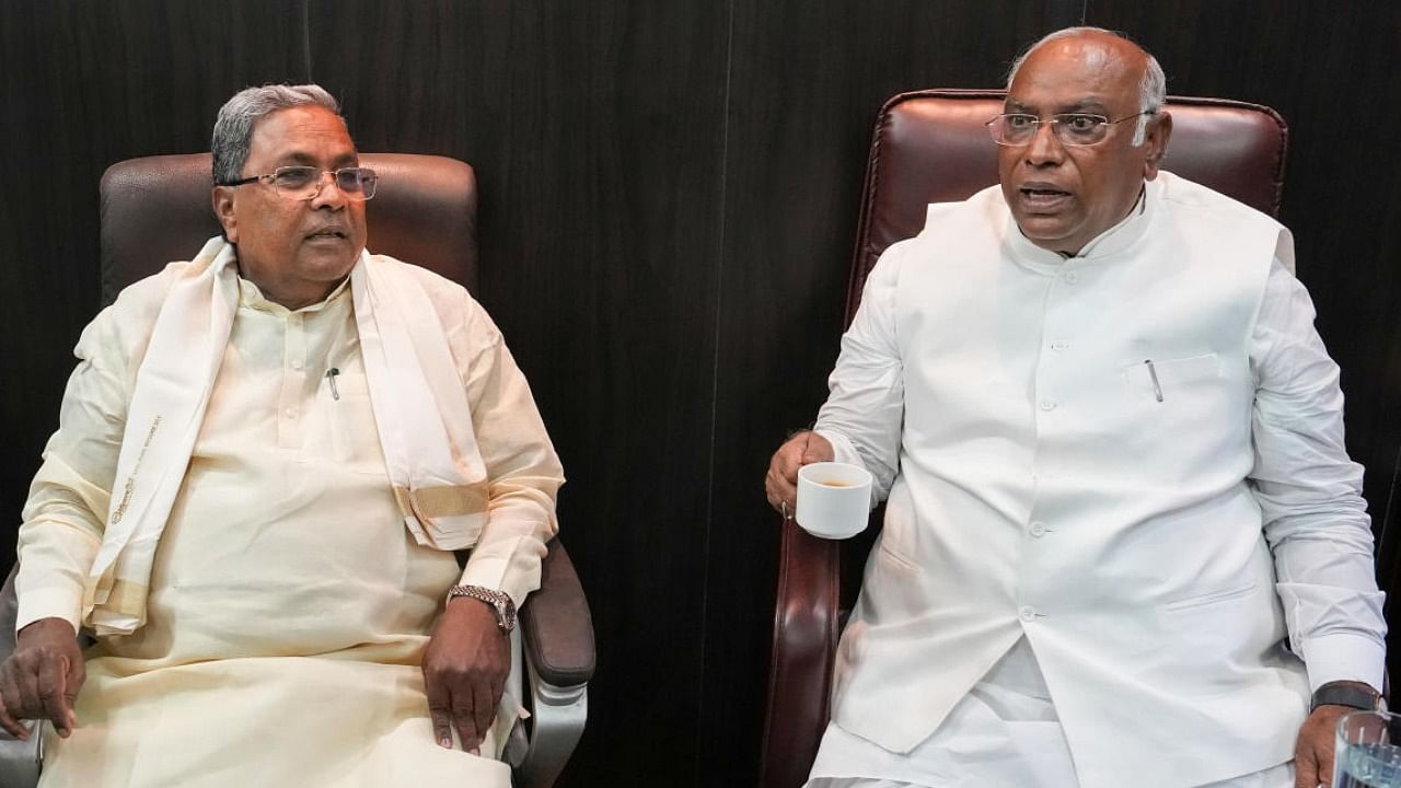 Mallikarjun Kharge with former CM Siddaramaiah after casting votes in Bengaluru on Monday. Credit: PTI Photo