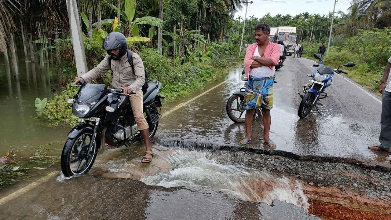 A road is washed away on Nittur-Cheluru stretch in Gubbi taluk of Tumakuru district. Credit: DH Photo