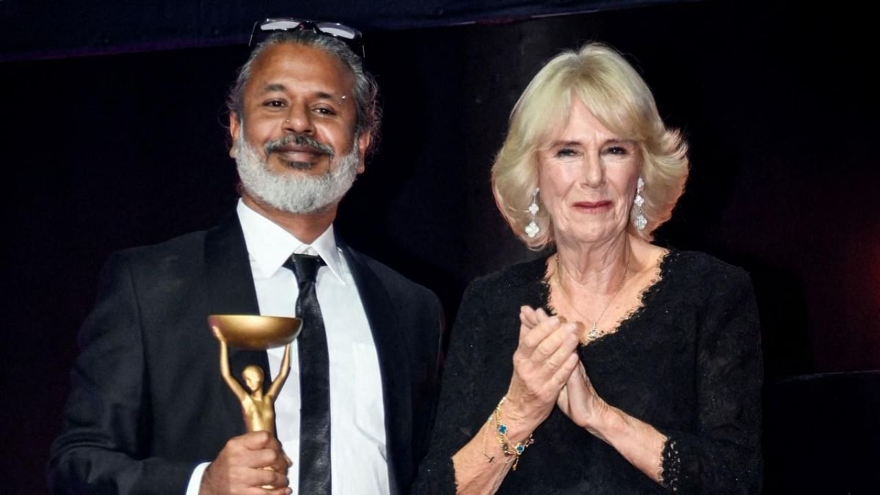 Sri Lankan writer Shehan Karunatilaka (L) poses next to Britain's Camilla, Queen Consort (R) after winning the British Booker Prize for his novel "The Seven Moons of Maali Almeida". Credit: AFP Photo