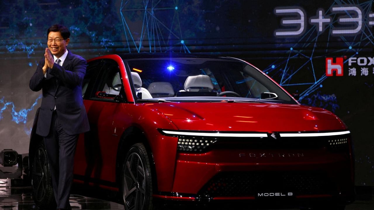 Foxconn Chairman Liu Young-way poses on stage with an electric vehicle, the Model C, during the company's annual Tech Day in Taipei. Credit: Reuters Photo