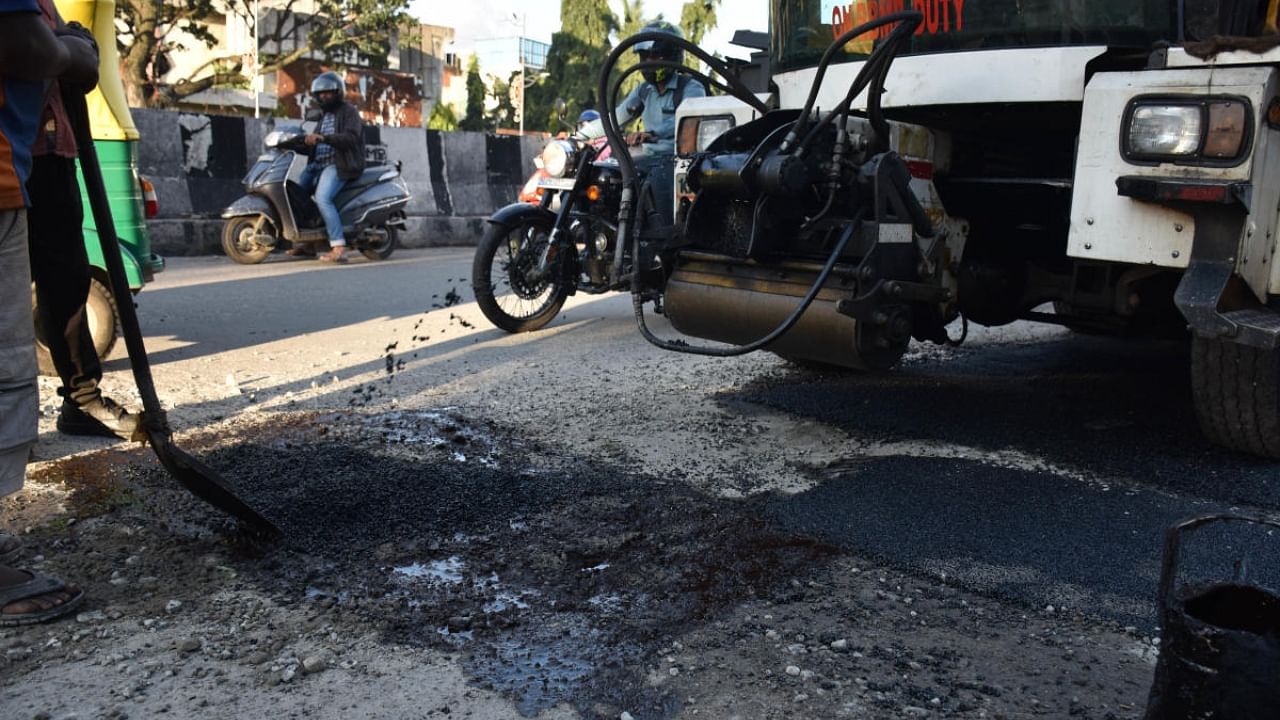 BBMP workers fill the pothole in Rajajinagar, Bengaluru, where the accident took place on Monday. Credit: DH Photo