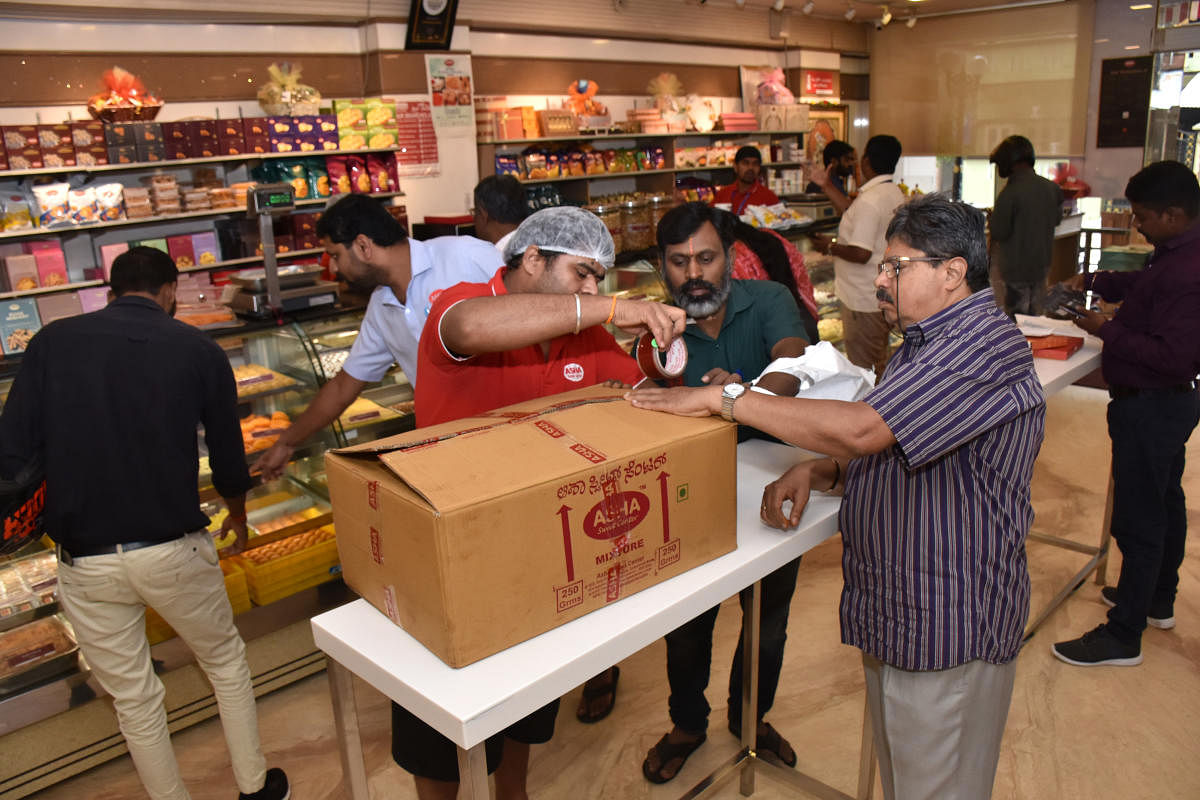 Packaging of sweet boxes at Asha Sweet Centre, 8th Cross, Malleswaram, on Tuesday. The brand has hired over 300 extra people across 16 city branches in the city to cope with the festive rush. DH Photo B K Janardhan