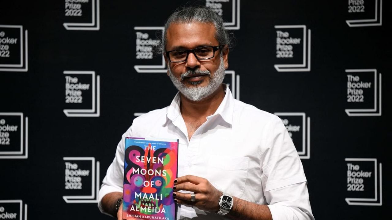 Sri Lankan author Shehan Karunatilaka holds his book 'The Seven Moons of Maali Almeida' during a photocall at the Shaw Theatre in King's Cross in London on October 14, 2022. Credit: AFP Photo