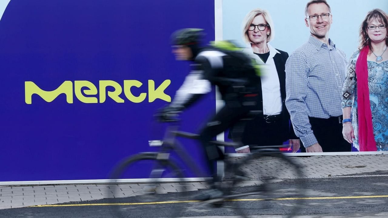 A cyclist drives past a logo of drugs and chemicals group Merck in Darmstadt. Credit: Reuters Photo