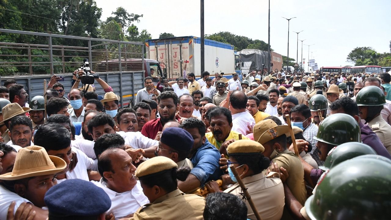 Former Minister Vinay Kumar Sorake being carried out to a waiting van by police after protestors attempted to lay siege to Suratkal toll plaza on Tuesday. Credit: DH Photo