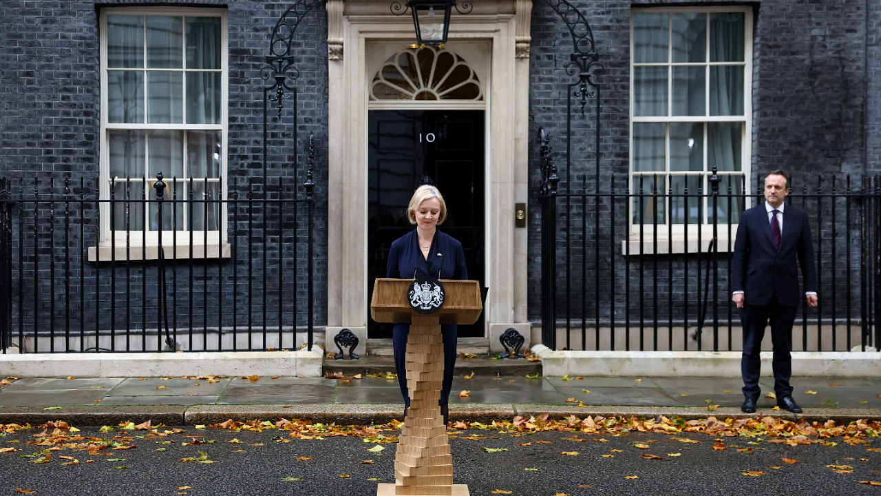 British Prime Minister Liz Truss announces her resignation, as her husband Hugh O'Leary stands nearby, outside Number 10 Downing Street, London. Credit: Reuters photo