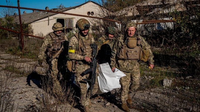 Soldiers carrying a bodybag containing the remains of an unknown Ukrainian soldier, found near the village of Shandrigolovo, Donetsk region, after the liberation of the area. Credit: AFP Photo