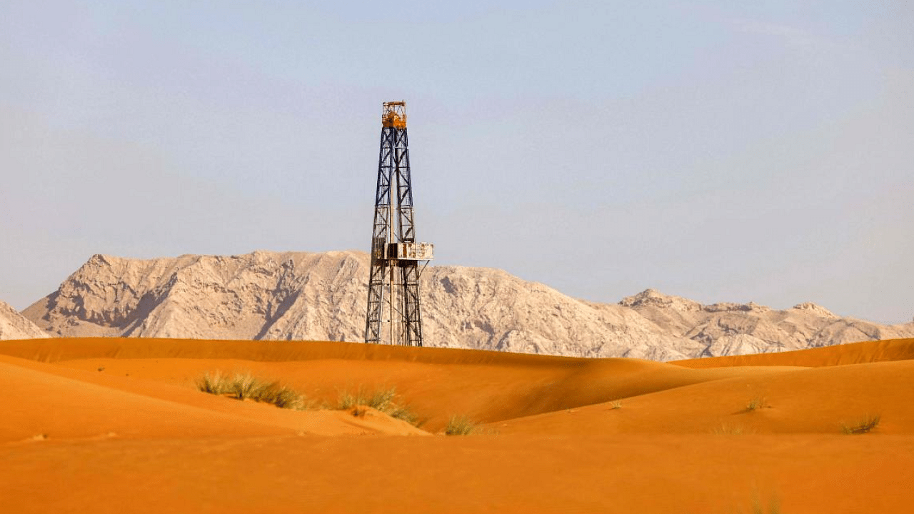 View of an oil drill pump amidst the sand dunes in the desert of the Gulf emirates. Credit: AFP Photo