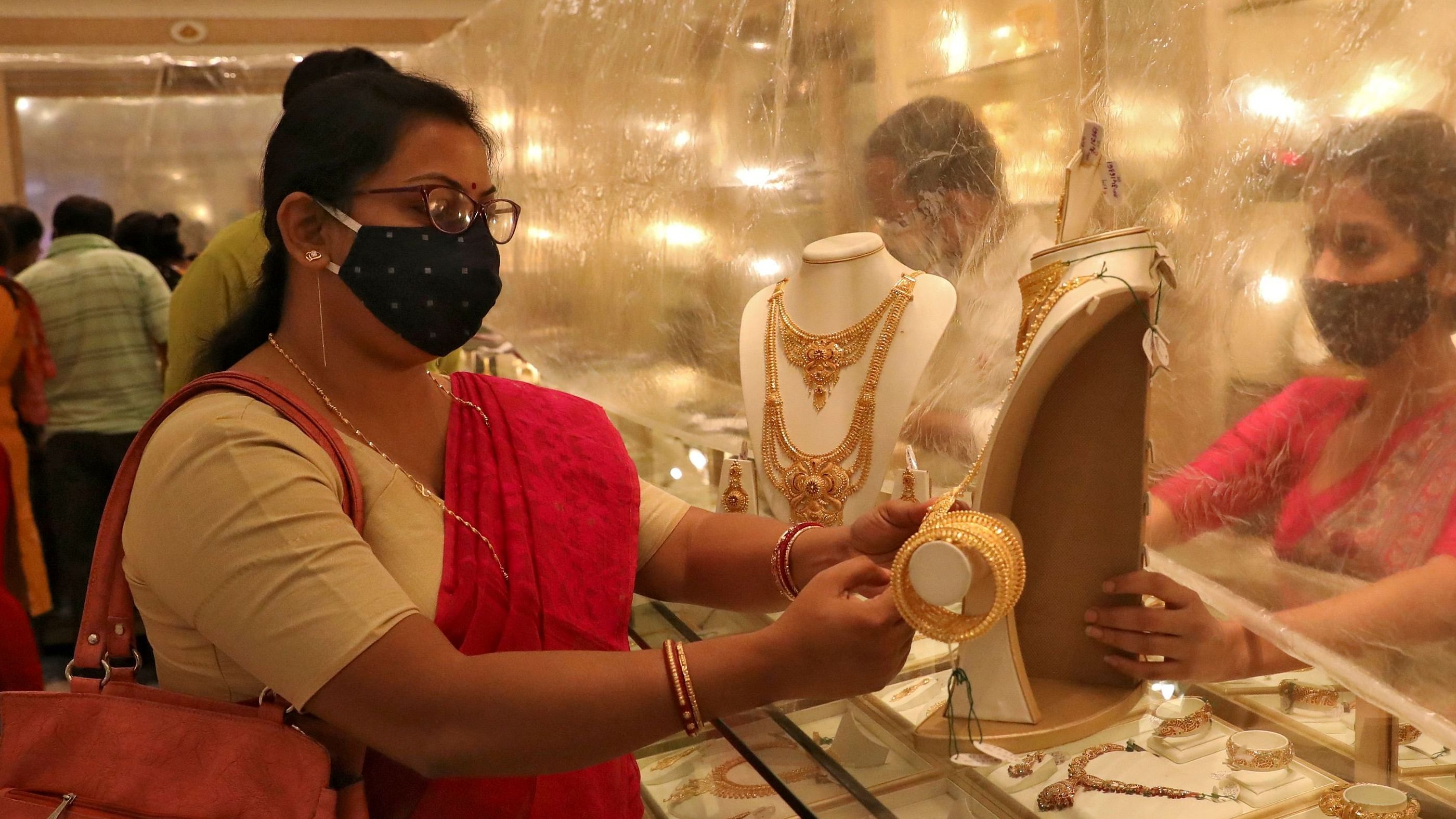 Woman looks at a gold necklace at a jewellery showroom during Dhanteras. Credit: Reuters Photo