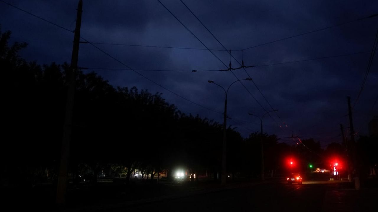 Cars move along a dark street during electricity shortage, amid Russia's attack on Ukraine, in Mykolaiv, Ukraine October 20, 2022. Credit: Reuters Photo