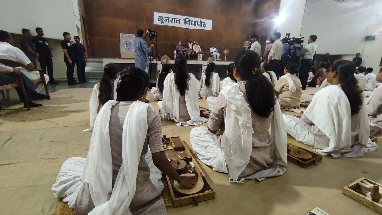 Students spinning charkha at Gujarat Vidyapith while welcoming the new chancellor. Credit: DH Photo