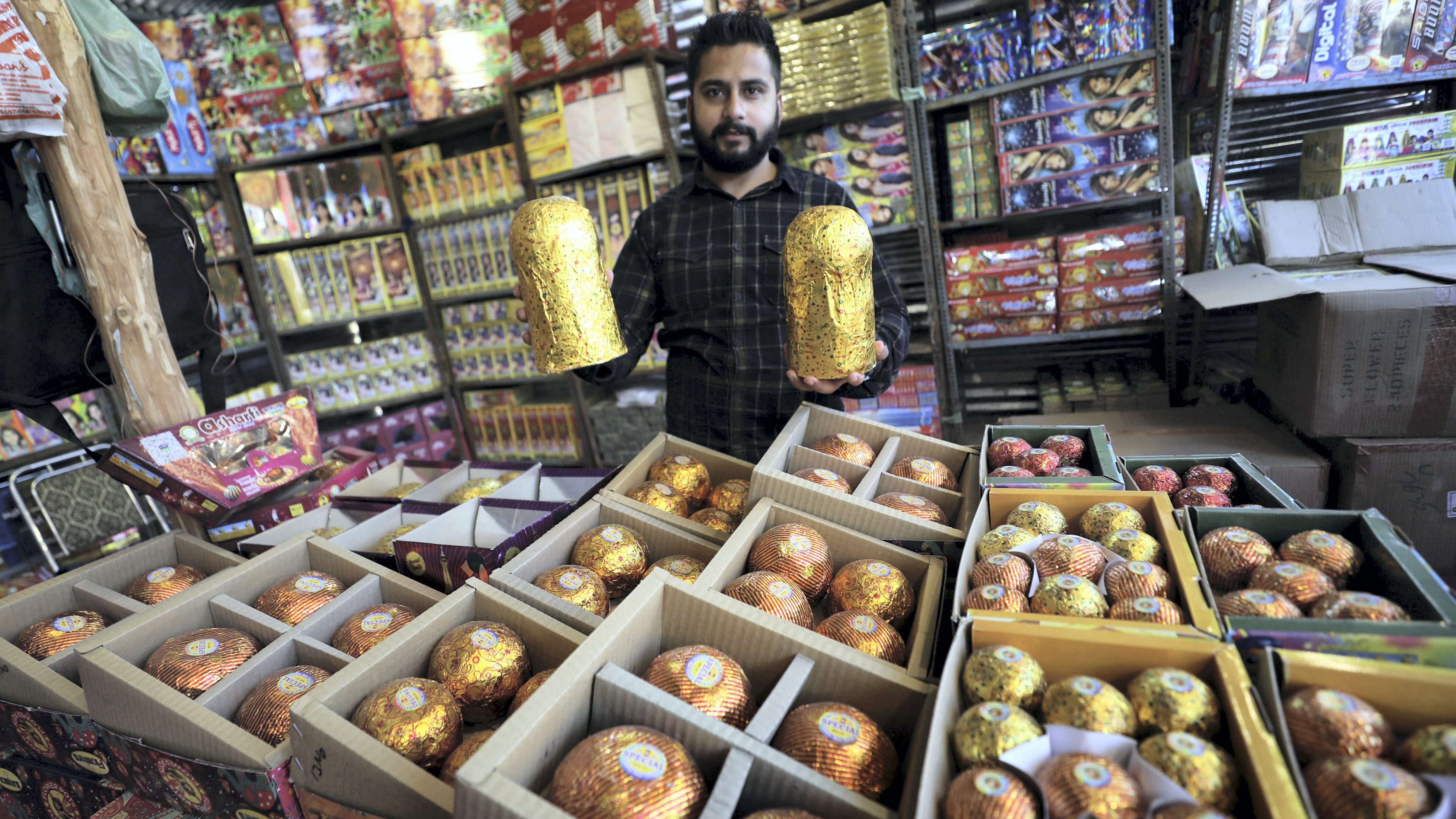 A shopkeeper shows firecrackers being sold at his shop ahead of the upcoming festival of Diwali. Credit: PTI Photo