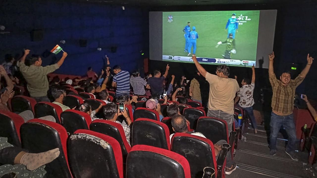 People celebrate as they watch the live screening of the ICC Men's T20 World Cup cricket match between India and Pakistan, at Satyam INOX, Patel Nagar in New Delhi. Credit: PTI Photo