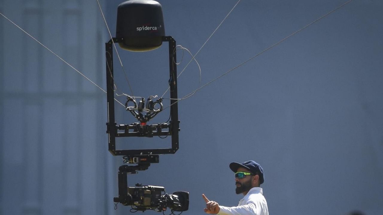 Virat Kohli checks out a spidercam – a cable-suspended camera system. Credit: AFP Photo