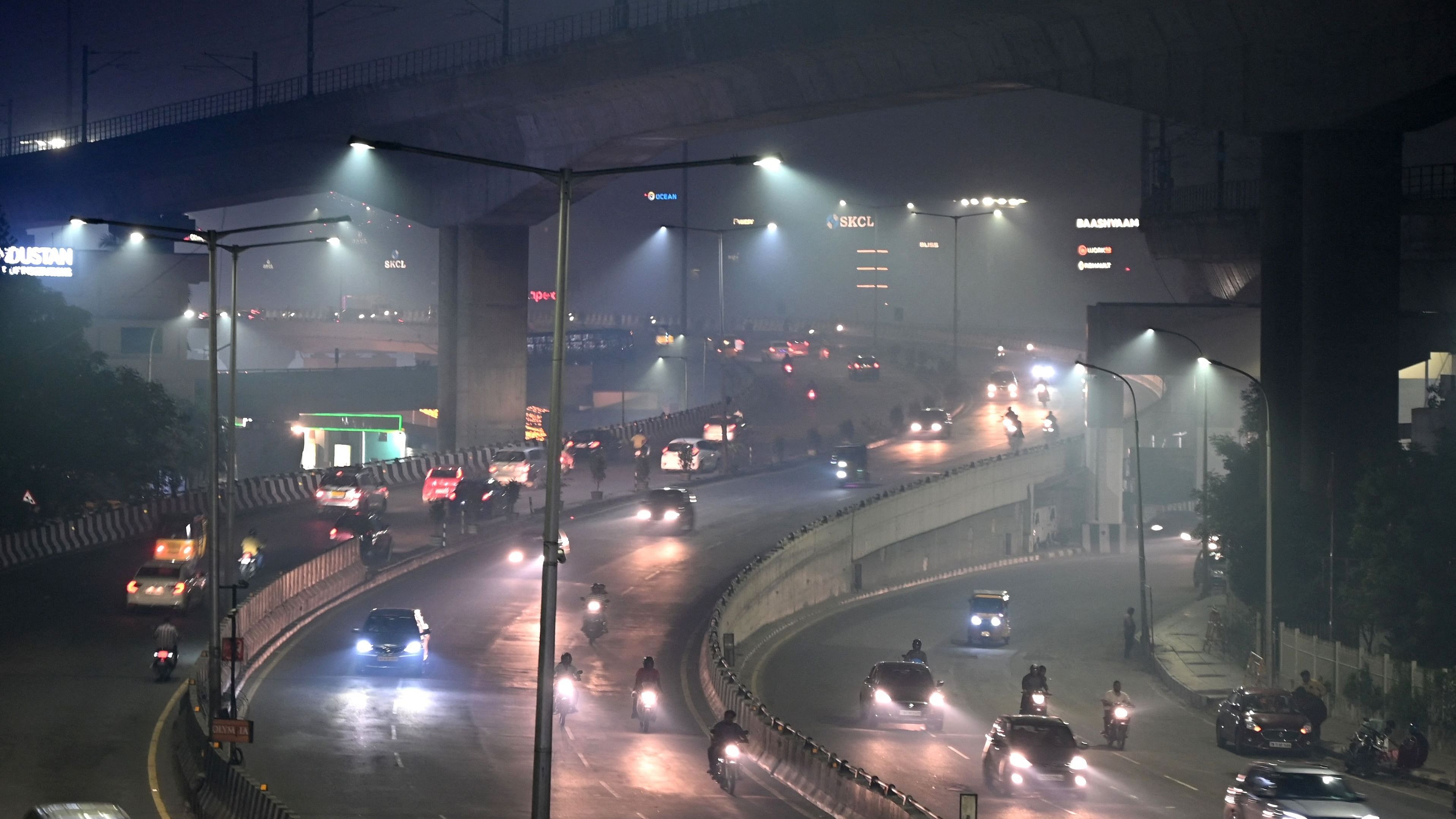 People commute in their vehicles along a road amid smoggy conditions on the occasion of Diwali. Credit: AFP Photo