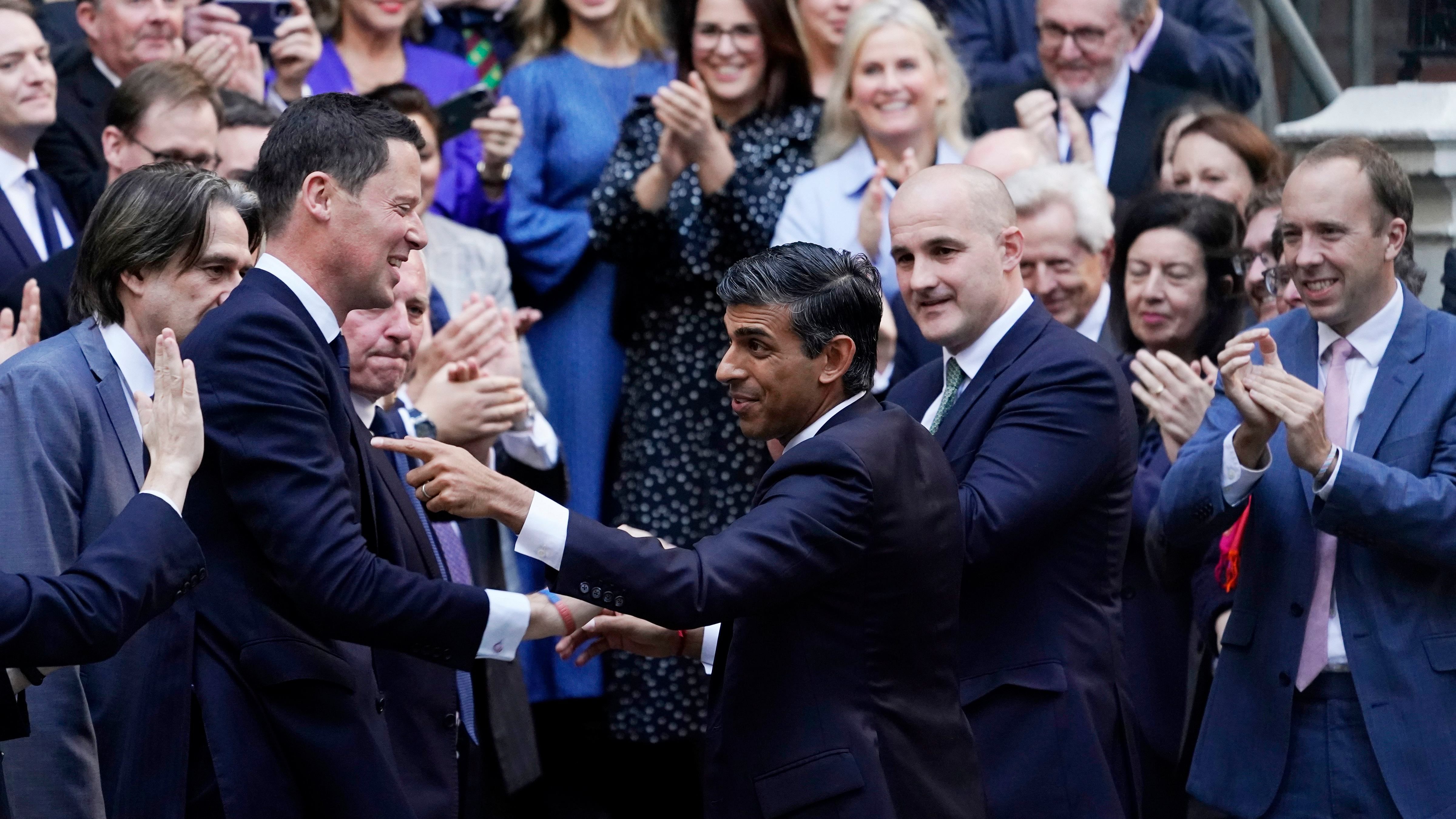 Rishi Sunak, centre, gestures as conservative MPs greet him after arriving at the Conservative Party leadership contest at the Conservative party Headquarters in London. Credit: AP Photo