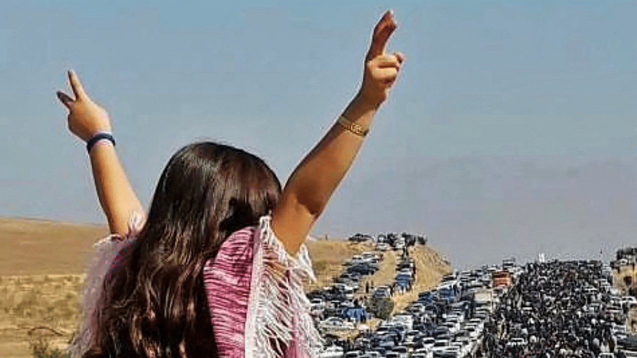 An unveiled woman standing on top of a vehicle as thousands make their way towards Aichi cemetery in Saqez, Mahsa Amini's home town in the western Iranian province of Kurdistan, to mark 40 days since her death. Credit: AFP Photo
