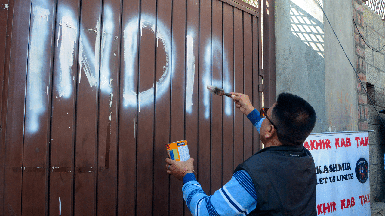 Kashmiri Pandits write 'India' on the entry gate of All Parties Hurriyat Conference office. Credit: PTI Photo