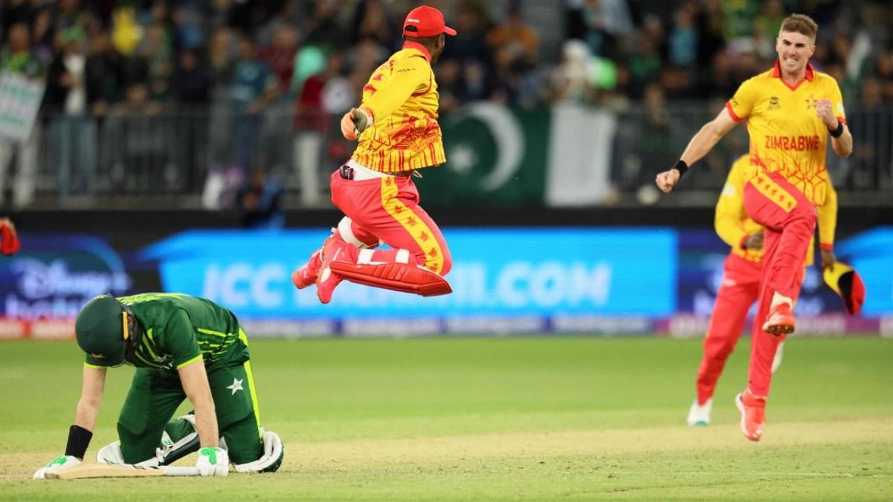 Zimbabwe's players celebrate their victory as Pakistan's Shaheen Shah Afridi (L) lies on the pitch at the end of the ICC men’s Twenty20 World Cup 2022 cricket match between Pakistan and Zimbabwe. Credit: AFP Photo
