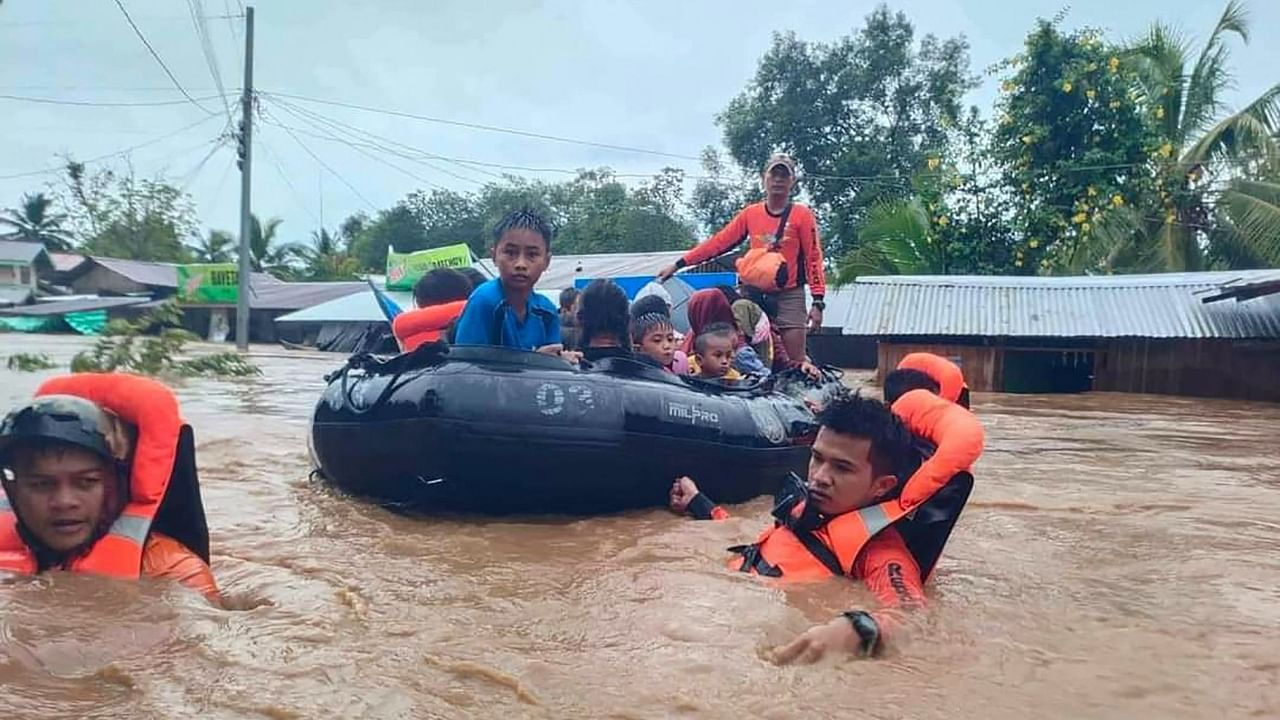 Rescue workers evacuate people from a flooded area due to heavy rain brought by Tropical Storm Nalgae in Parang, Maguindanao province, Philippines, October 28, 2022. Credit: AFP Photo