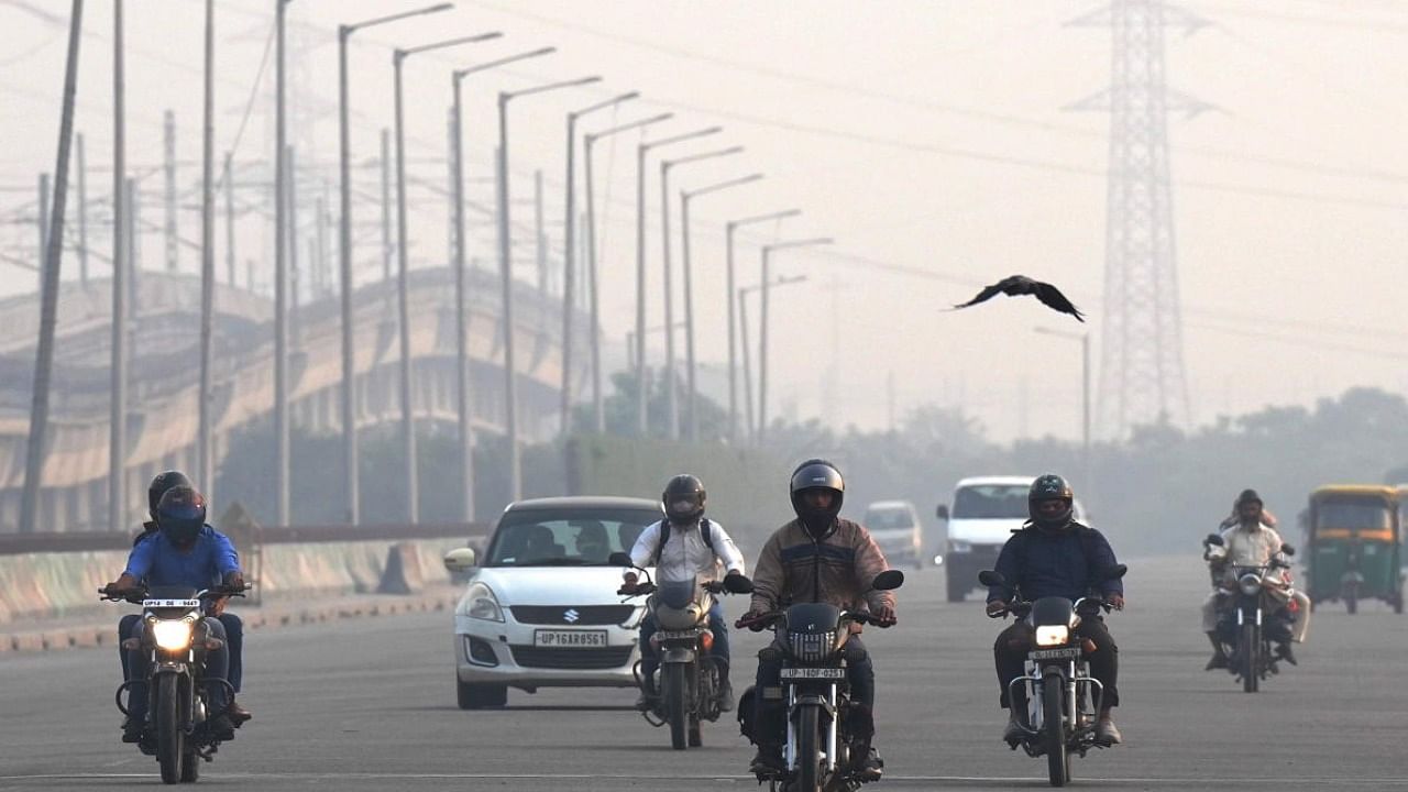 Vehicles ply on the road amid low visibility due to smog in New Delhi on Sunday. Credit: PTI Photo
