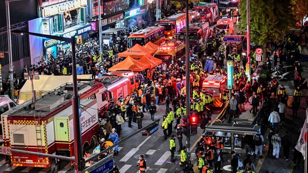 Onlookers, police and paramedics gather where dozens of people suffered cardiac arrest, in the popular nightlife district of Itaewon in Seoul. Credit: AFP Photo