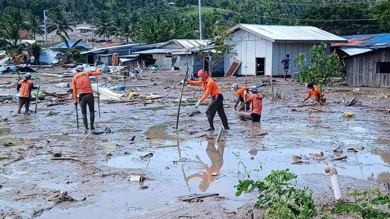 Rescue workers using makeshift poles as they conduct search operations in Datu Odin Sinsuat, Maguindanao province. Credit: AFP Photo