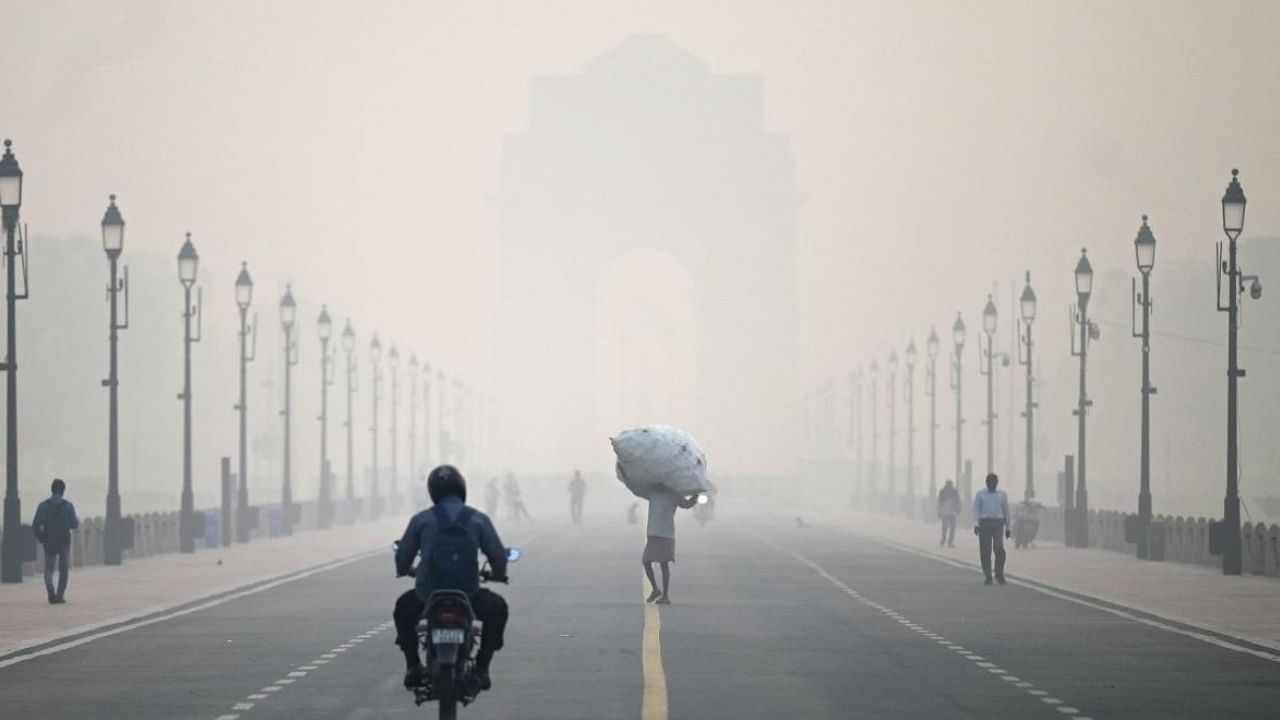 Commuters on the road in front of India Gate amid smoggy conditions in New Delhi on Tuesday morning. Credit: PTI Photo
