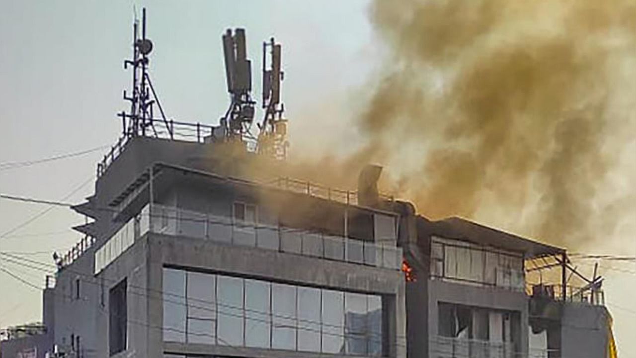 Smoke rises from a fire that broke out in a restaurant located on the top floor of a commercial building at Lullanagar area in Pune. Credit: PTI Photo