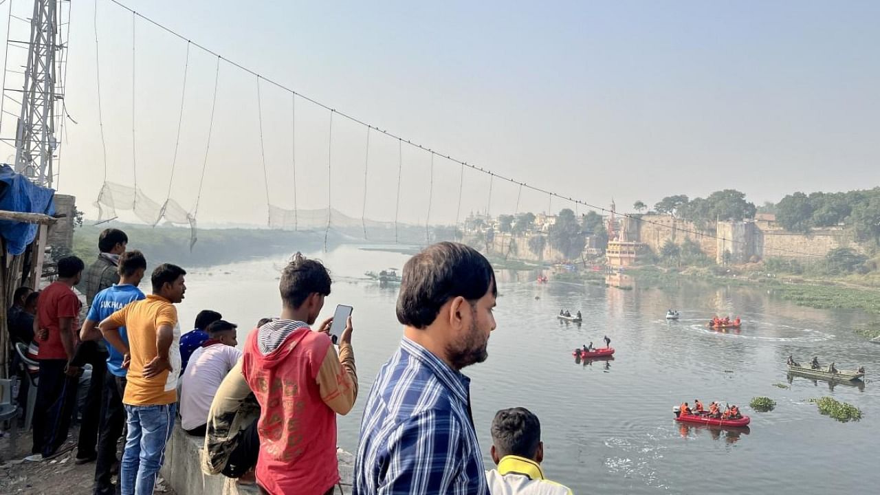 Locals at the Morbi bridge collapse site during a rescue operation. Credit: PTI Photo