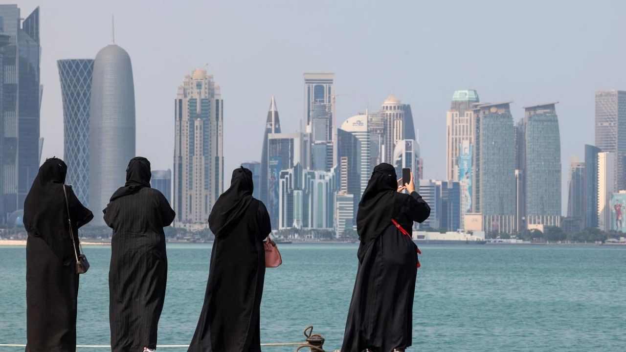 Women take pictures of the Qatari capital Doha's skyline ahead of the FIFA 2022 Football World Cup. Credit: AFP Photo