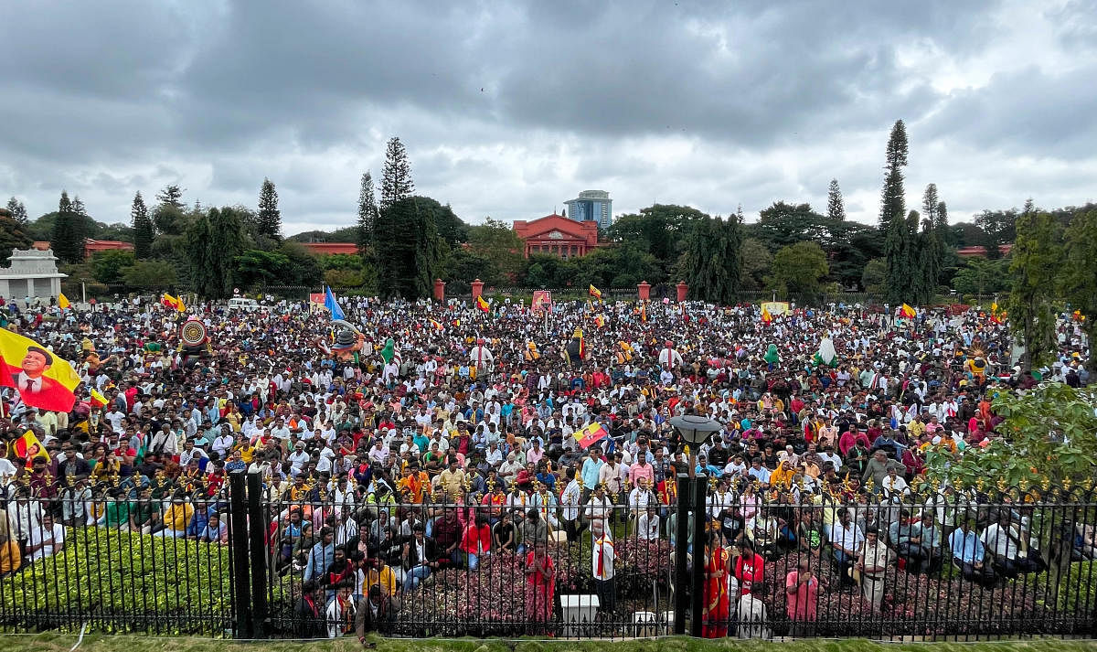 Hundreds of fans brave the rain as they witness the Karnataka Ratna Award ceremony at Vidhana Soudha on Tuesday. DH PHOTO/PUSHKAR V