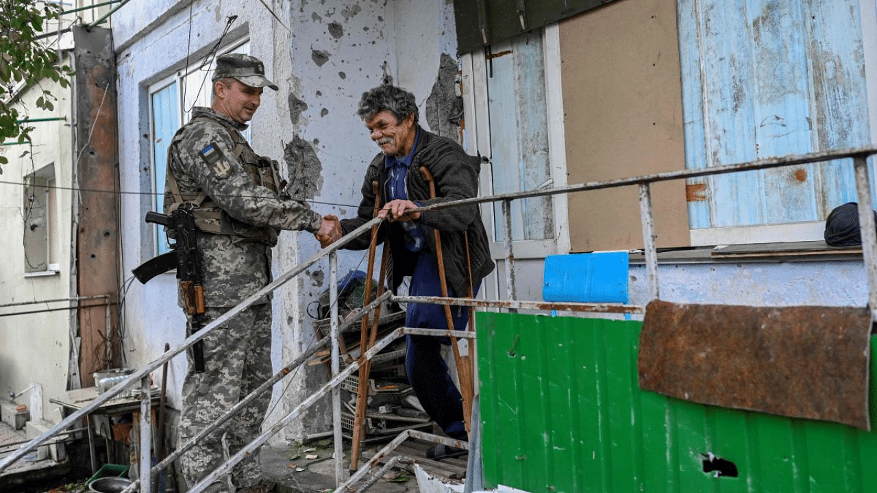 Ukrainian serviceman interacts with a civilian in Kherson. Credit: AFP Photo