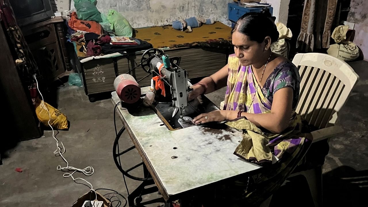 Reena Ben works on a solar-powered sewing machine to stitch clothes inside her one-room house in Modhera, India's first round-the-clock solar-powered village, in the western state of Gujarat, India, October 19, 2022. Credit: Reuters Photo