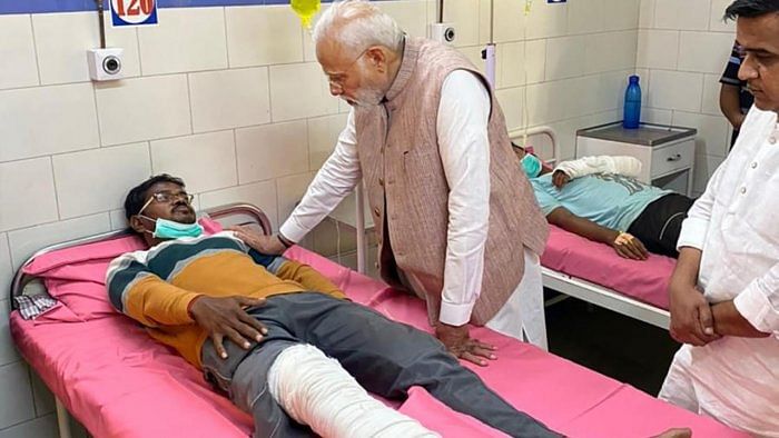 Modi meets a victim injured the collapse of a suspension bridge over the Machchhu river, at Civil Hospital in Morbi district, Tuesday, November 1, 2022. Credit: PTI Photo