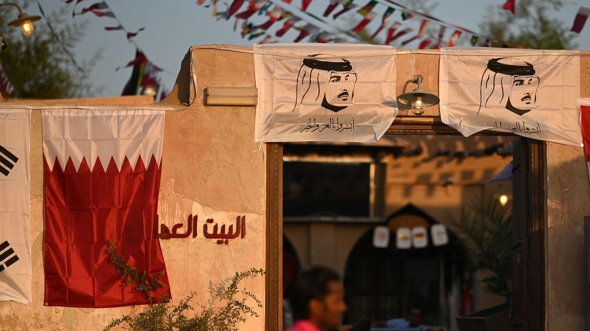 A man walks past a restaurant adorned with FIFA World Cup playing countries’ flags in a market area in Doha on November 3, 2022, ahead of the Qatar 2022 FIFA World Cup football tournament. Credit: AFP Photo