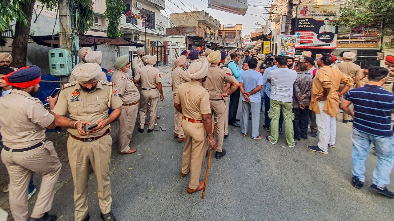 Police personnel and locals at the site after Shiv Sena leader Sudhir Suri was shot dead by unidentified people, in Amritsar. Credit: PTI Photo