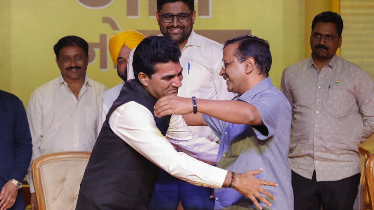 Delhi CM Arvind Kejriwal greets Aam Aadmi Party (AAP) party’s chief ministerial candidate Isudan Gadhvi during a public meeting ahead of Gujarat Assembly elections, in Ahmedabad, Friday, Nov. 4, 2022. Punjab CM Bhagwant Mann is also seen. Credit: PTI Photo