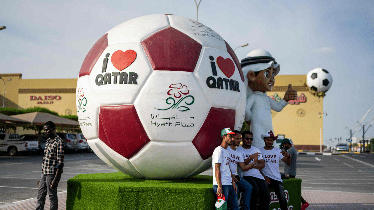 People have their picture taken with a large art installation at a parking lot of a shopping mall ahead of the Qatar 2022 FIFA World Cup. Credit: AFP Photo